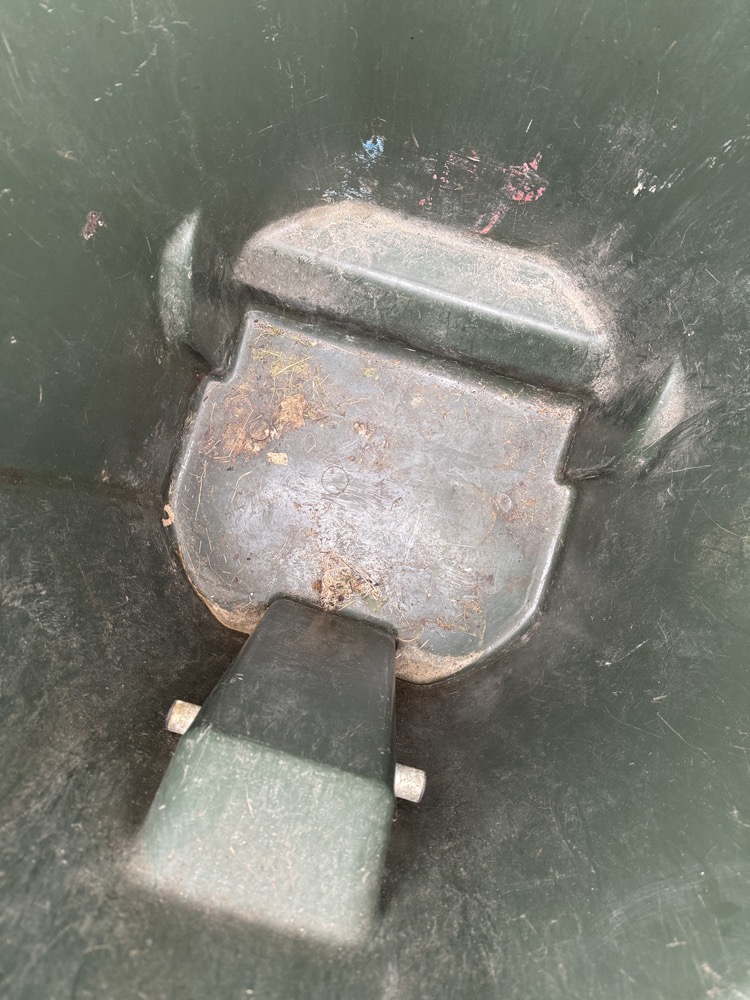 Grimy trash can bottom before pressure washing