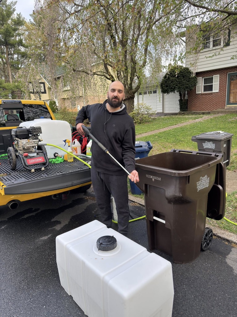 Shane Lane pressure washing a trash can with 190-degree hot water in the Lehigh Valley